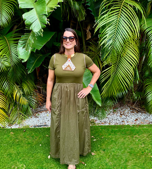 Woman in a green dress standing in front of tropical plants
