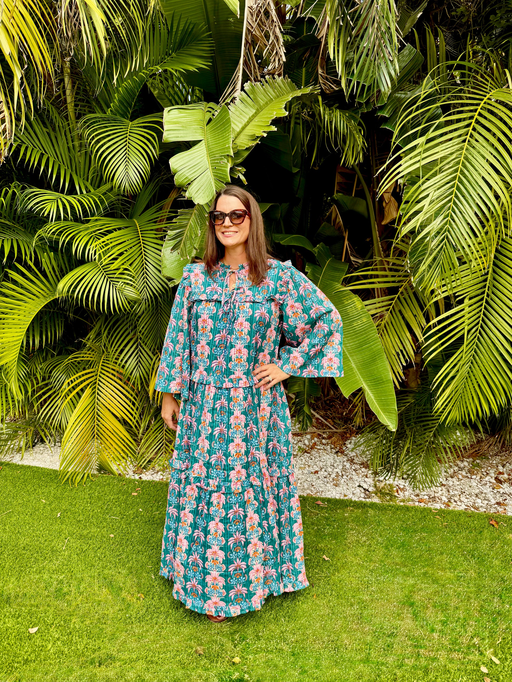 Woman in a floral dress standing in front of tropical plants
